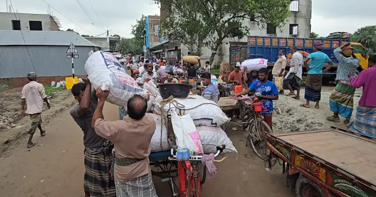 ঠেনঠেনিয়া বাজারে পেঁয়াজ তুলছেন চাষিরা